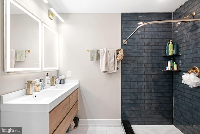 bathroom with baseboards, a stall shower, and vanity