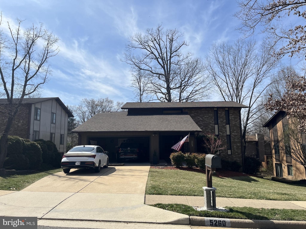 view of front of house featuring concrete driveway, roof with shingles, a garage, and a front yard