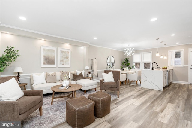 living room with a notable chandelier, recessed lighting, light wood finished floors, and ornamental molding