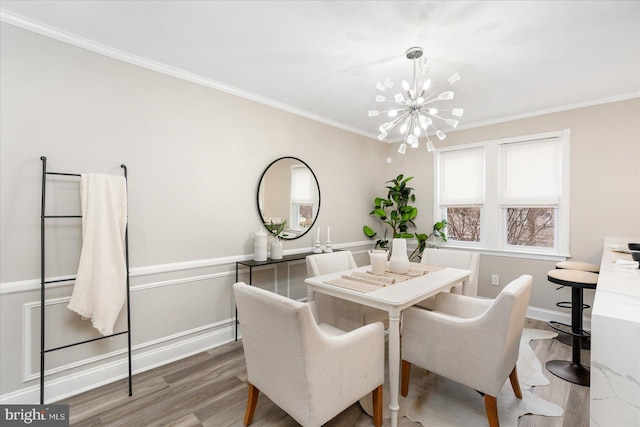 dining space featuring crown molding, wood finished floors, baseboards, and a chandelier