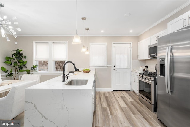 kitchen featuring ornamental molding, stainless steel appliances, light wood-type flooring, and a sink