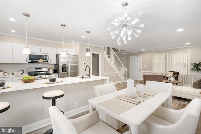 dining area featuring stairway, wood finished floors, recessed lighting, crown molding, and a chandelier