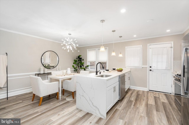 kitchen with light wood-style flooring, a peninsula, stainless steel appliances, and a sink