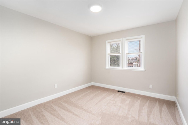 unfurnished room featuring baseboards, visible vents, and carpet floors