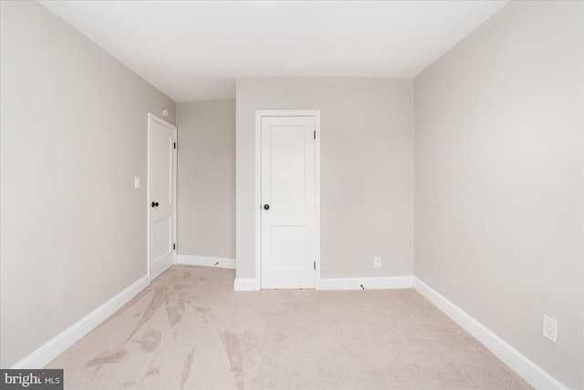 carpeted spare room with baseboards