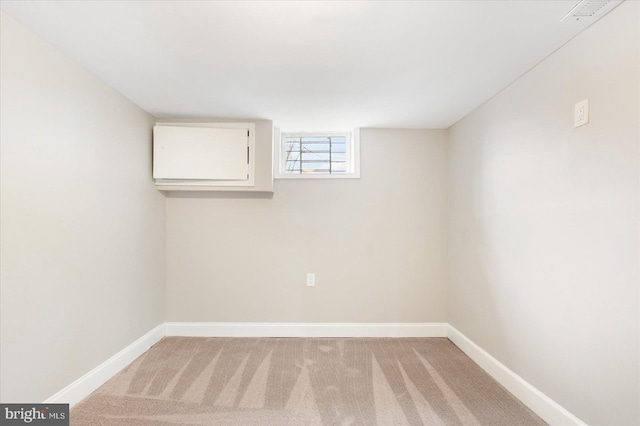 unfurnished room featuring baseboards and light colored carpet