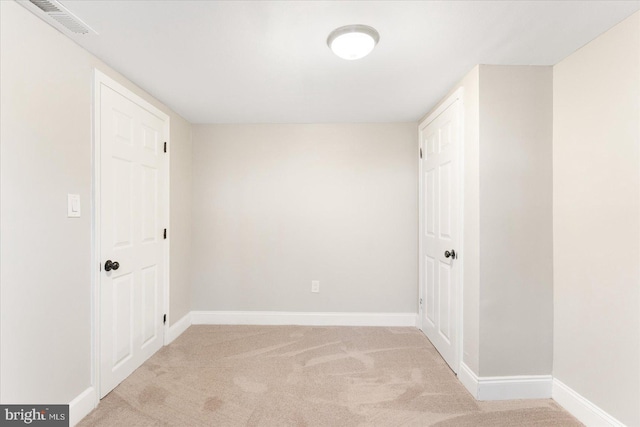 unfurnished room featuring carpet flooring, visible vents, and baseboards