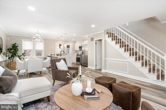 living room featuring recessed lighting, light wood-style floors, stairs, and crown molding