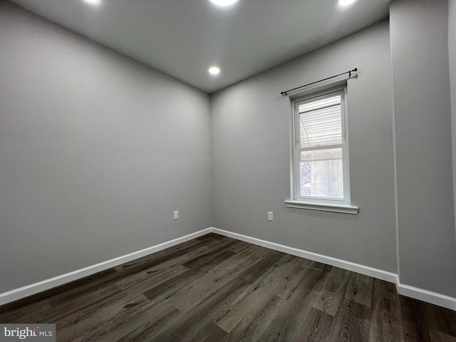 empty room featuring dark wood finished floors, recessed lighting, and baseboards