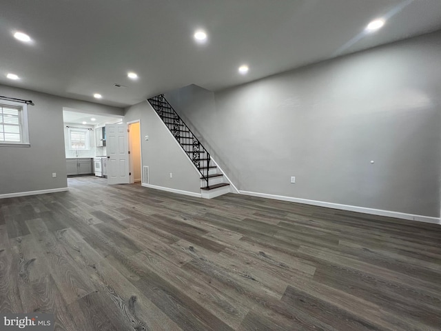 basement featuring dark wood-type flooring, stairway, recessed lighting, and baseboards