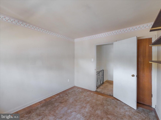 unfurnished room with wood finished floors and baseboards