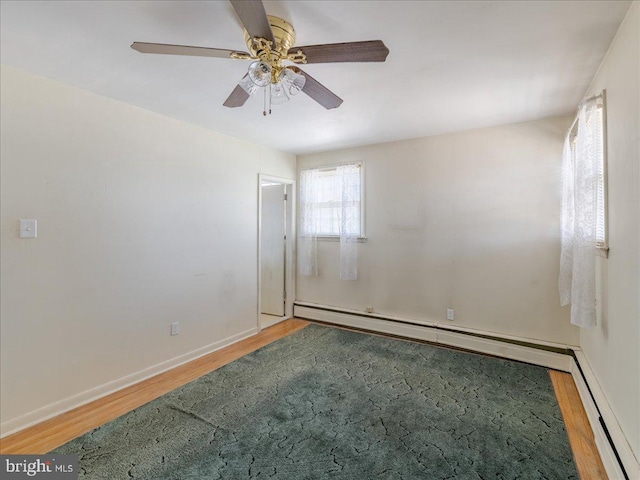 unfurnished room with ceiling fan, wood finished floors, baseboards, and a baseboard radiator