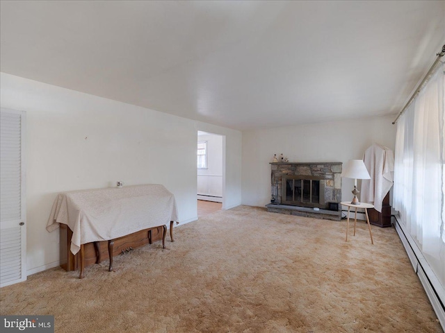 carpeted bedroom featuring a stone fireplace and baseboard heating