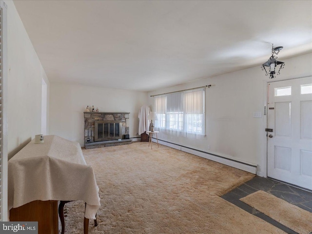 living area with carpet floors, a stone fireplace, and a baseboard radiator