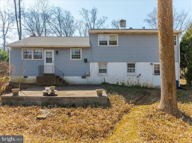 rear view of property featuring a patio and a chimney