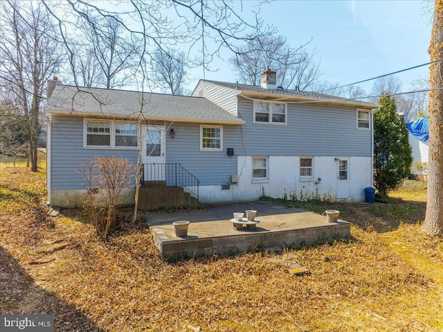 back of house with a patio area and a chimney