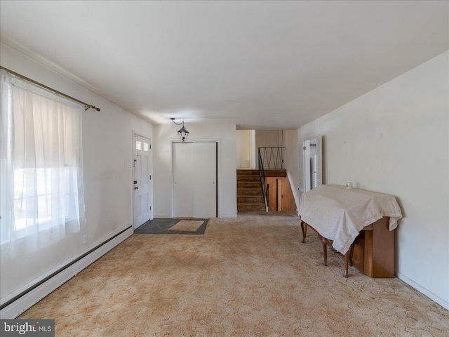 foyer featuring stairs, carpet, and a baseboard radiator