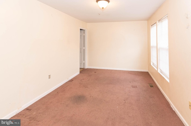 carpeted empty room with visible vents and baseboards