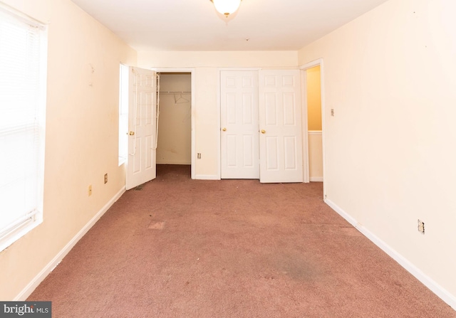 unfurnished bedroom with carpet, baseboards, and a closet