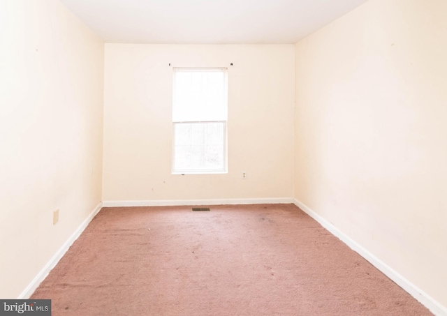 carpeted empty room featuring baseboards