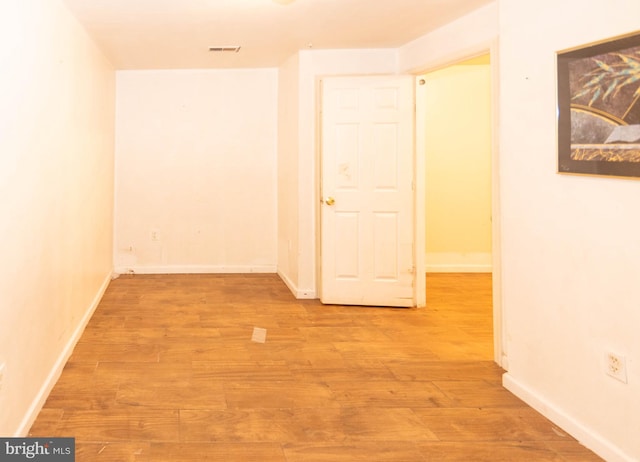 hallway with light wood finished floors and baseboards