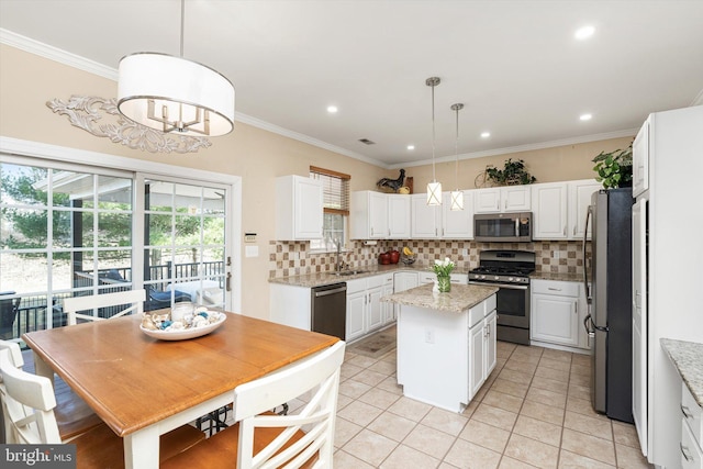 kitchen featuring a kitchen island, tasteful backsplash, appliances with stainless steel finishes, white cabinets, and crown molding