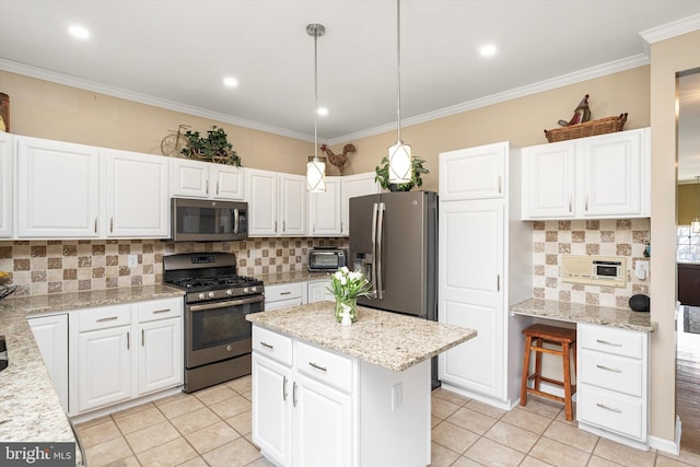 kitchen featuring a kitchen island, white cabinets, stainless steel appliances, and ornamental molding