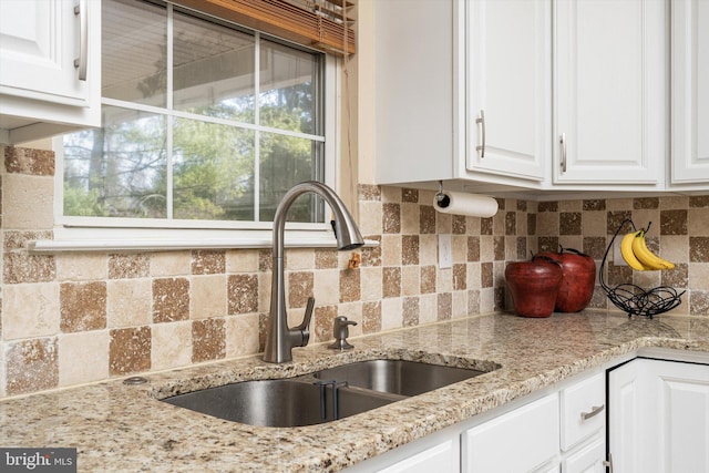 kitchen with white cabinetry, a healthy amount of sunlight, backsplash, and a sink