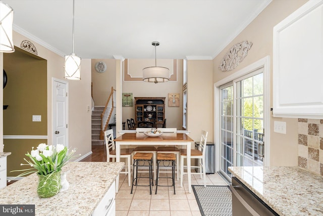 dining area featuring baseboards, light tile patterned flooring, stairs, and crown molding