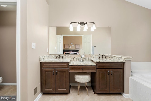 bathroom with double vanity, a bath, and a sink