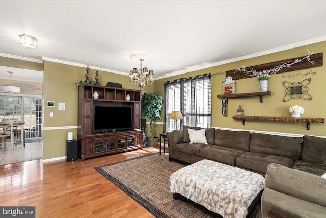 living room featuring light wood finished floors, baseboards, an inviting chandelier, and ornamental molding