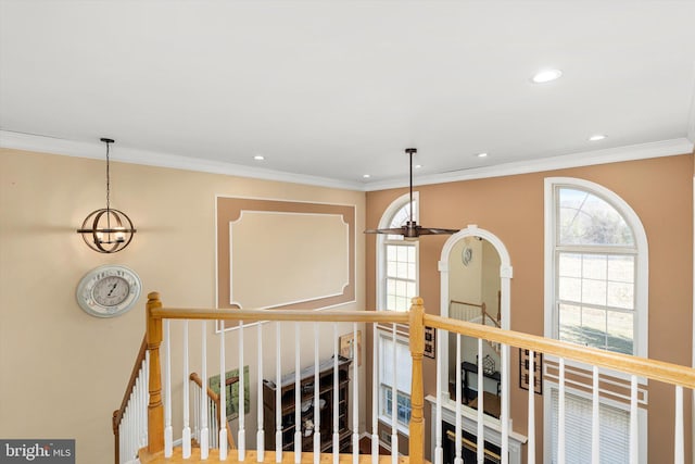 hall with recessed lighting, plenty of natural light, an upstairs landing, and crown molding