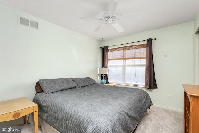 carpeted bedroom with visible vents, baseboards, and ceiling fan