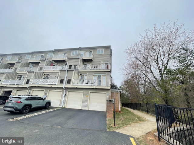 exterior space with brick siding, driveway, a garage, and fence