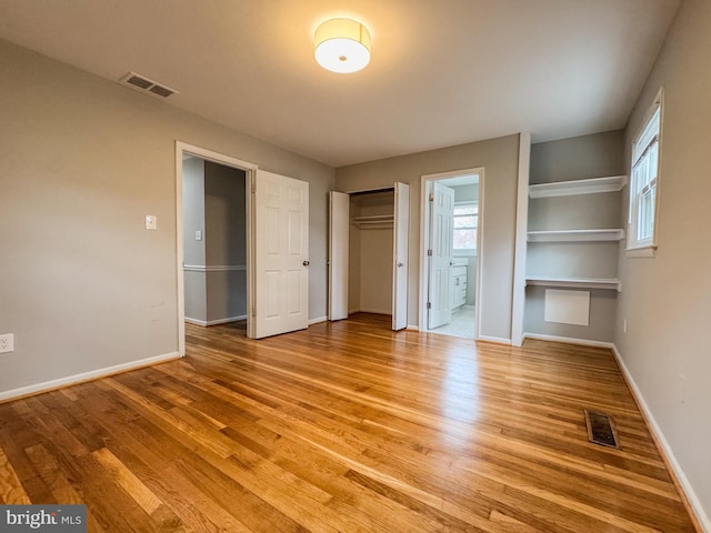 unfurnished bedroom featuring light wood-type flooring, visible vents, and baseboards