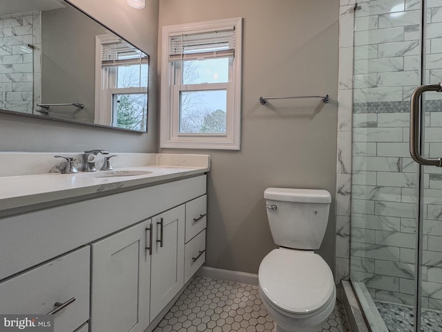 full bath with vanity, a shower stall, toilet, and baseboards