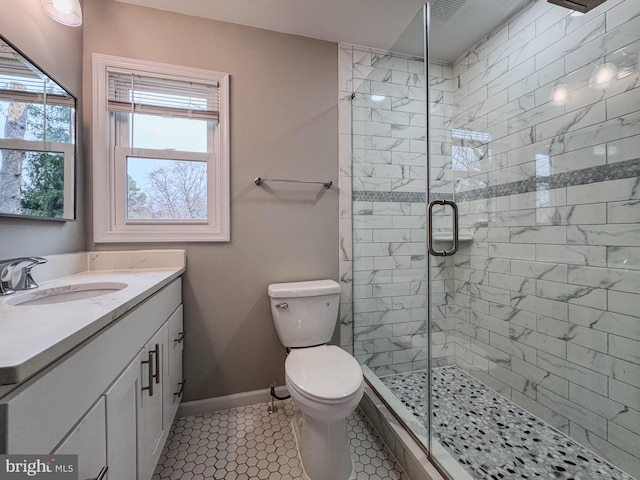 full bath featuring toilet, a stall shower, vanity, and baseboards