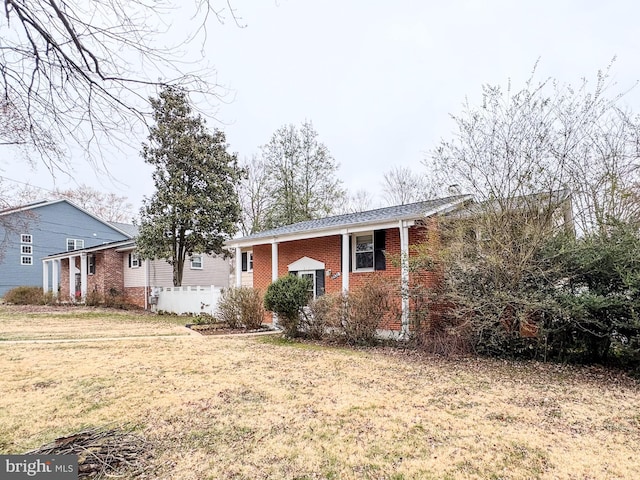 view of front facade featuring brick siding and a front yard