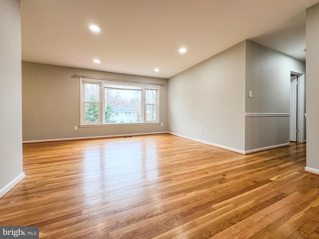 unfurnished living room with recessed lighting, baseboards, and light wood finished floors