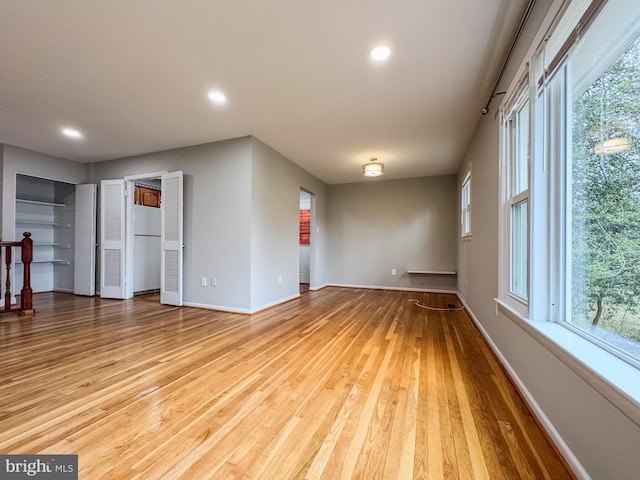 spare room featuring recessed lighting, baseboards, and wood finished floors