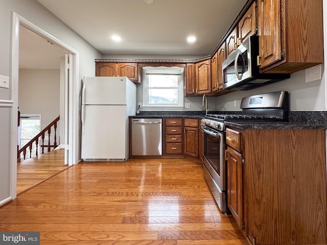 kitchen featuring recessed lighting, light wood-style flooring, appliances with stainless steel finishes, and brown cabinets