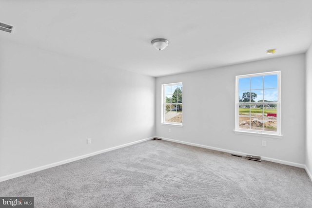 unfurnished room with visible vents, baseboards, and carpet flooring