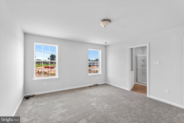 spare room with carpet and baseboards