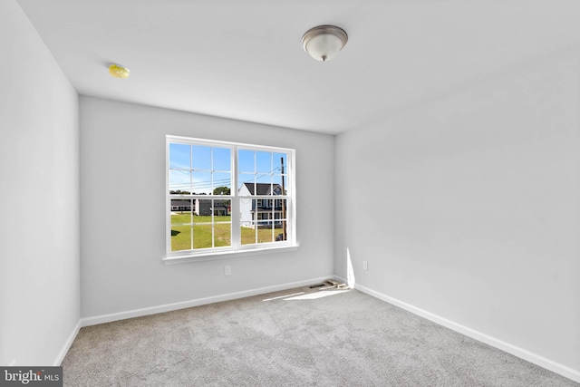 carpeted spare room with baseboards