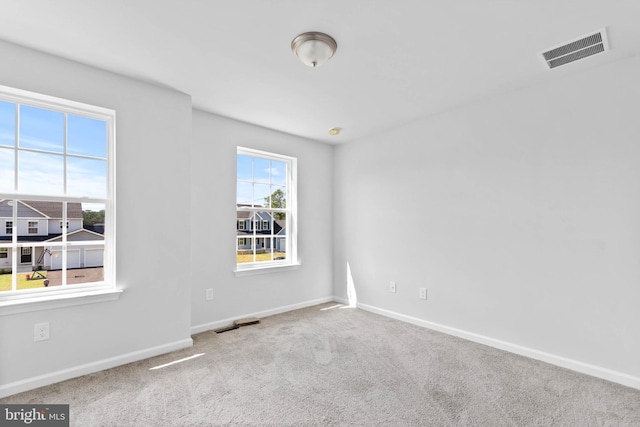 carpeted empty room with visible vents and baseboards