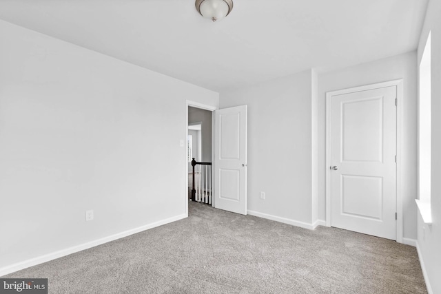 unfurnished bedroom with baseboards and carpet