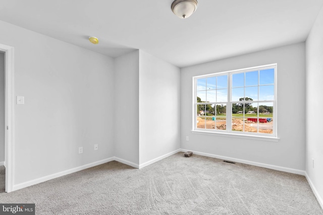 carpeted empty room with visible vents and baseboards