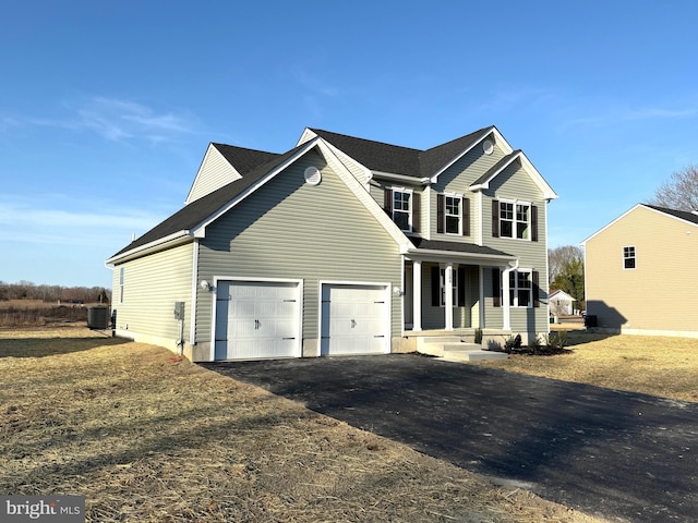 view of front facade featuring aphalt driveway, central air condition unit, covered porch, and a garage