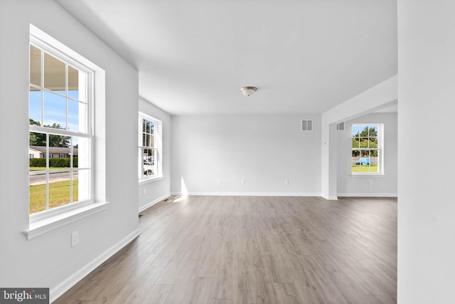 unfurnished room with visible vents, baseboards, and wood finished floors