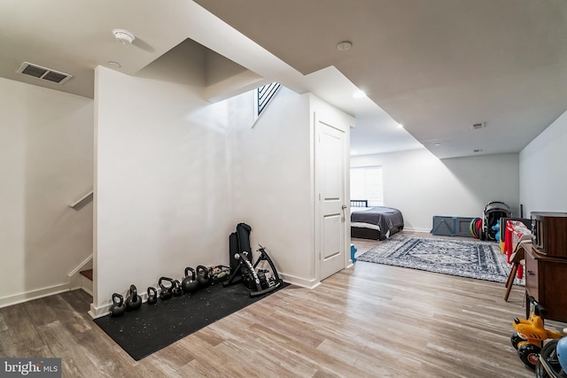 workout room featuring visible vents, baseboards, and wood finished floors